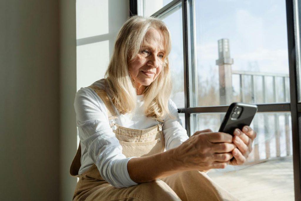 Older woman using a smartphone for everyday banking and financial services